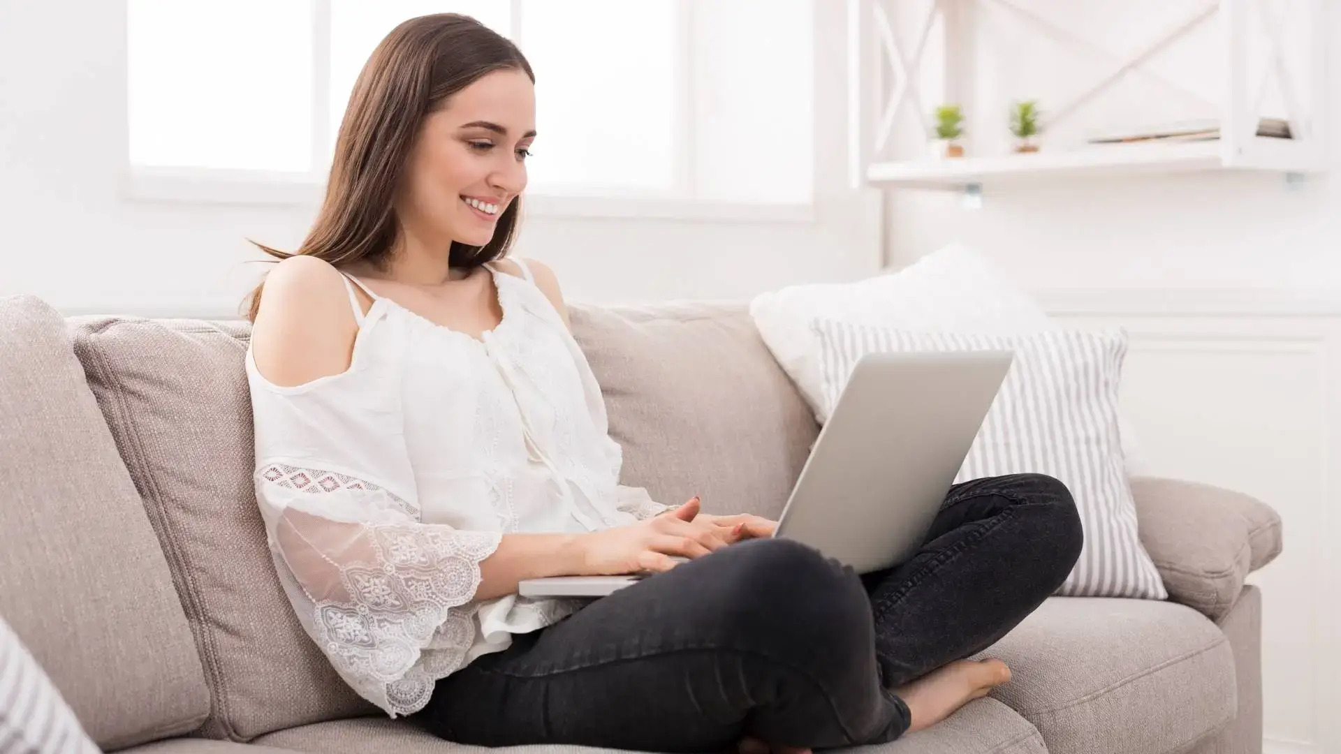 Właścicielka firmy siedząca przed laptopem na kanapie